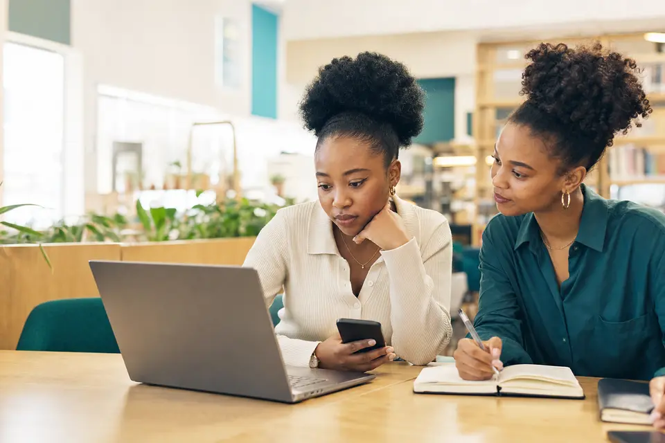 Two young South African applicants checking an opportunity source together